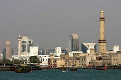 
Dubai Creek, the historic focal point of life in the city, is a natural seawater inlet that cuts through the city's centre and separates Deira from Bur Dubai. The creek is alive with trade and tradition, the loading and unloading of trade ships that still travel ancient routes, and the beautiful promenades that line both sides of the water. In this view from near the mouth, the Grand Mosque dominates the Bur Dubai skyline, while the buildings of Deira are behind, including the Etisalat building with the golf ball on top, the Dubai Creek Tower, the curved National Bank of Dubai, and finally the triangular Dubai Chamber of Commerce building.
